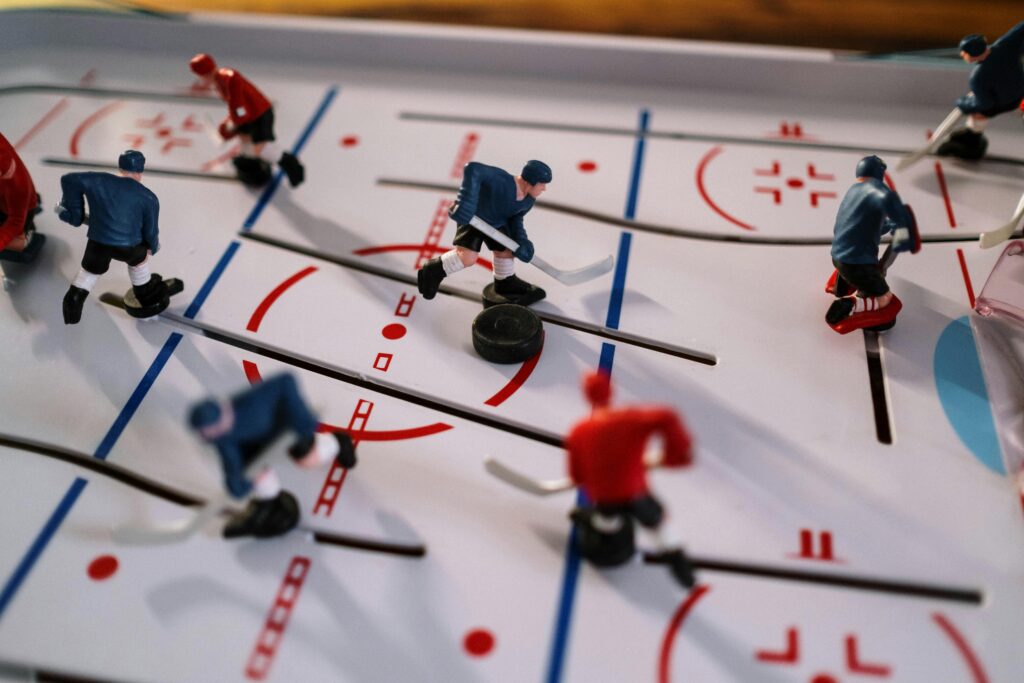 Closeup on a table hockey game showcasing figurines in motion on the playing field, prediction market opportunities